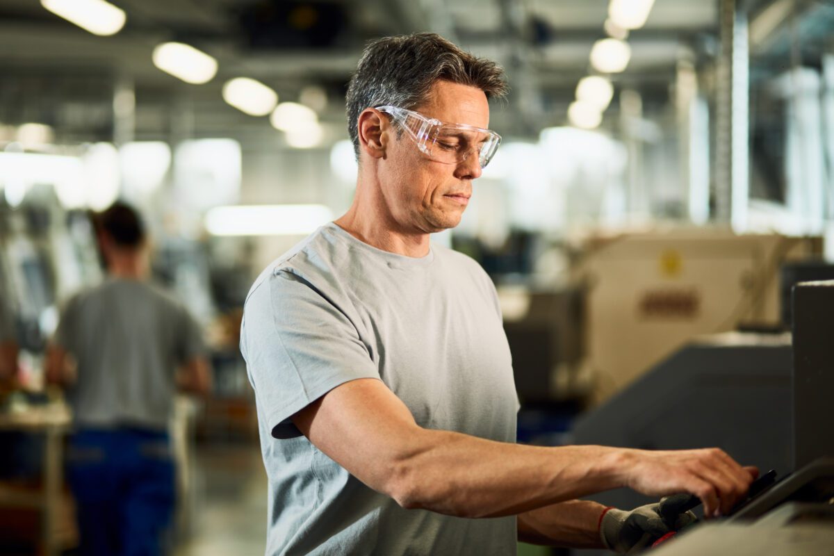 Industrial engineer operating a CNC machine at production line